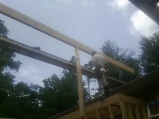 Carpenter setting a ridge beam over a new addition frame — Ice Dam Removal by Roofing Brothers in Cresskill