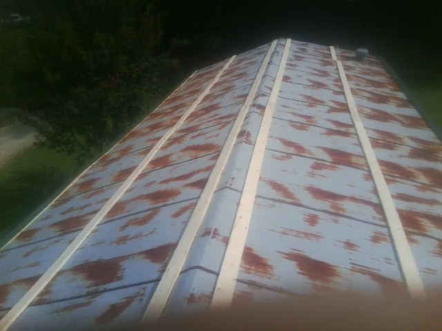 Rusted metal roof panels with new wood purlins before replacement — Storm Damage Roof Repair in Cresskill by Roofing Brothers