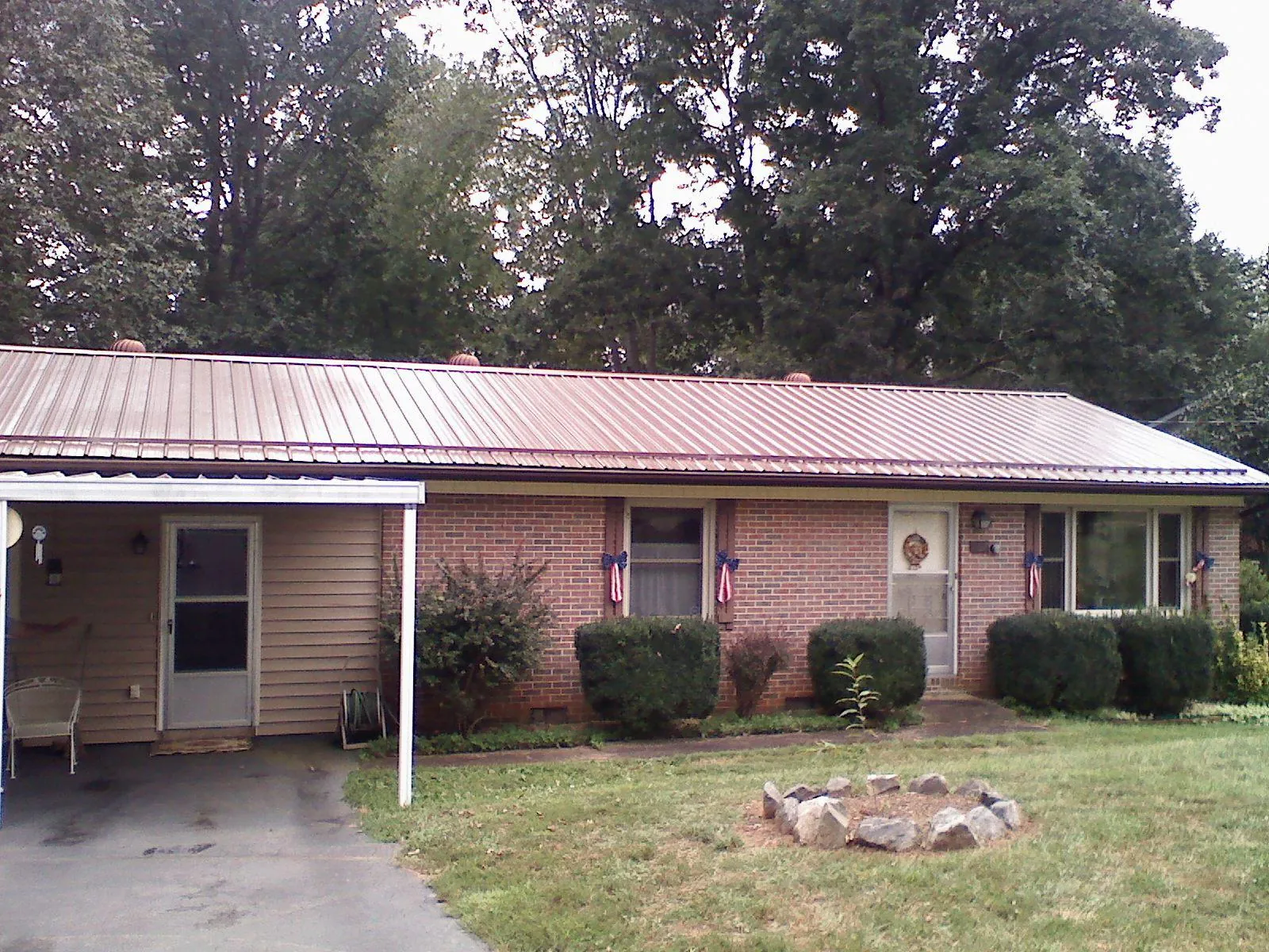 Bronze metal roof and carport on a brick ranch home — Roof Repair work by our crew in Cresskill